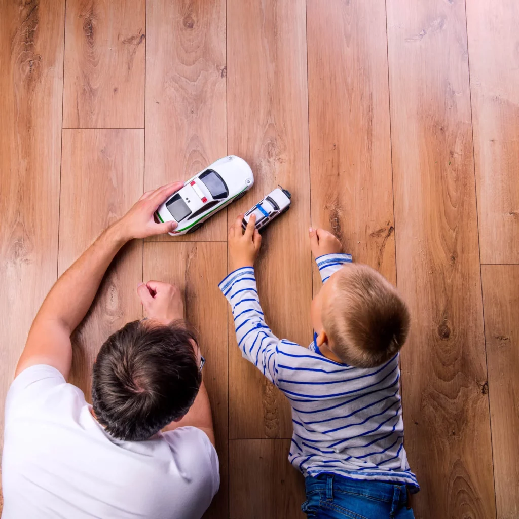 best-hardwood-for-families Dad & sun playing with toys | DeHaan Tile & Floor Covering